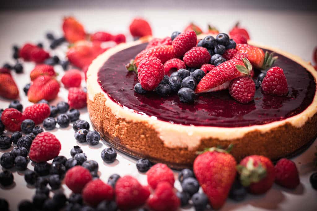 baked mixed berry cheesecake surrounded by berries