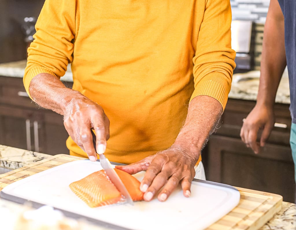 pawpaw and kolby kash cutting a salmon filet