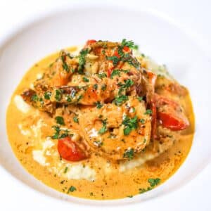 salmon and grits with shrimp gravy in a white bowl