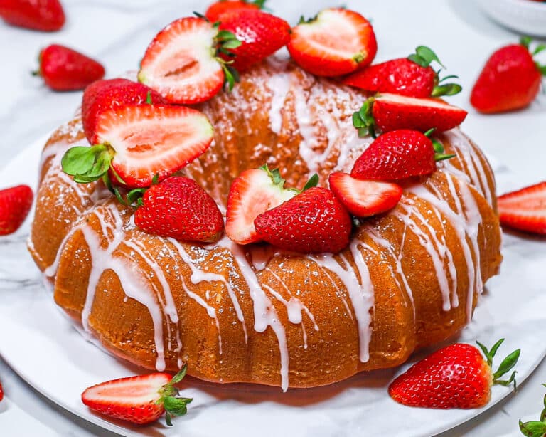 strawberry bundt cake topped with fresh strawberries and icing