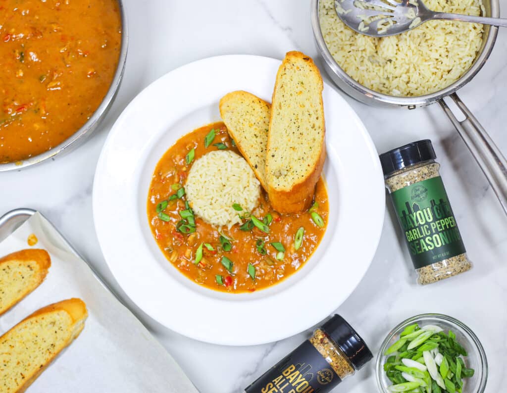 etouffee in a white bowl with garlic bread