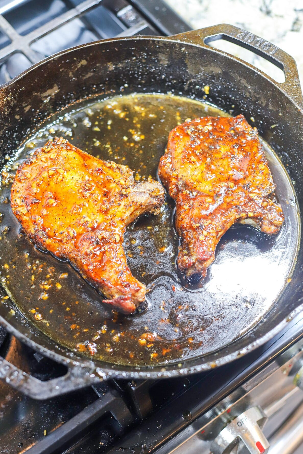 pork chop cooking in honey garlic glaze