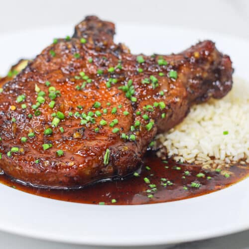 Honey Garlic Pork Chop plated with rice and Brussel sprouts