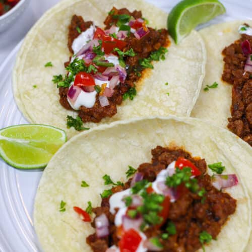 ground beef tacos with pico regally and sour cream on corn tortilla