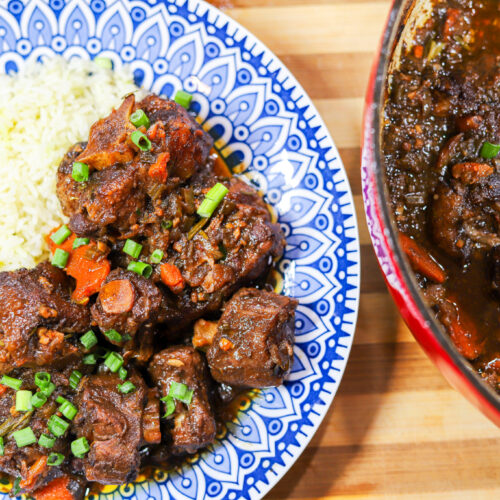 Southern Oxtails plated with rice and topped with green onion