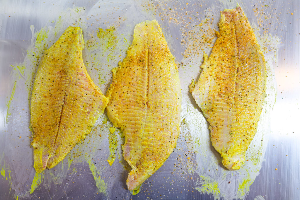 Coating catfish fillets with mustard before breading