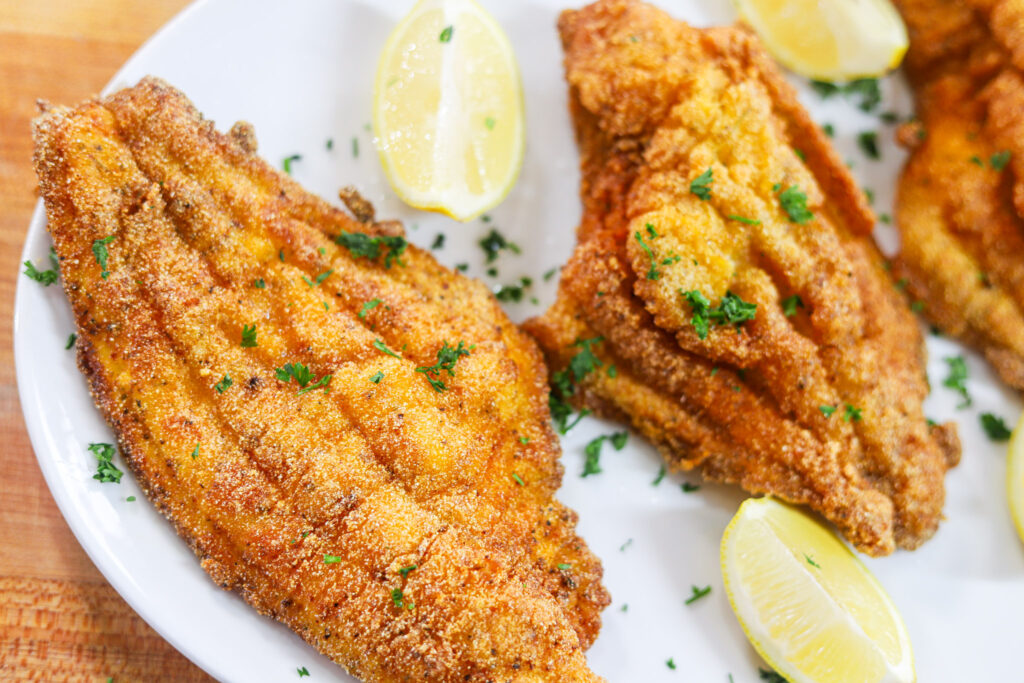 Golden crispy fried catfish recipe with fresh parsley and lemon