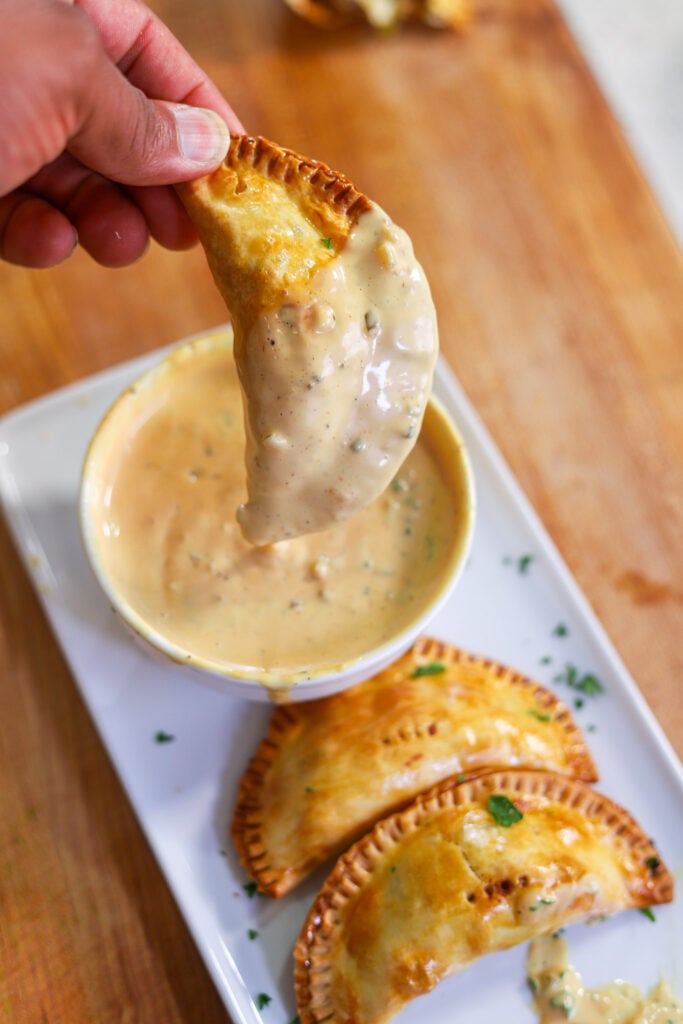 cheeseburger empanada dipped in homemade burger sauce