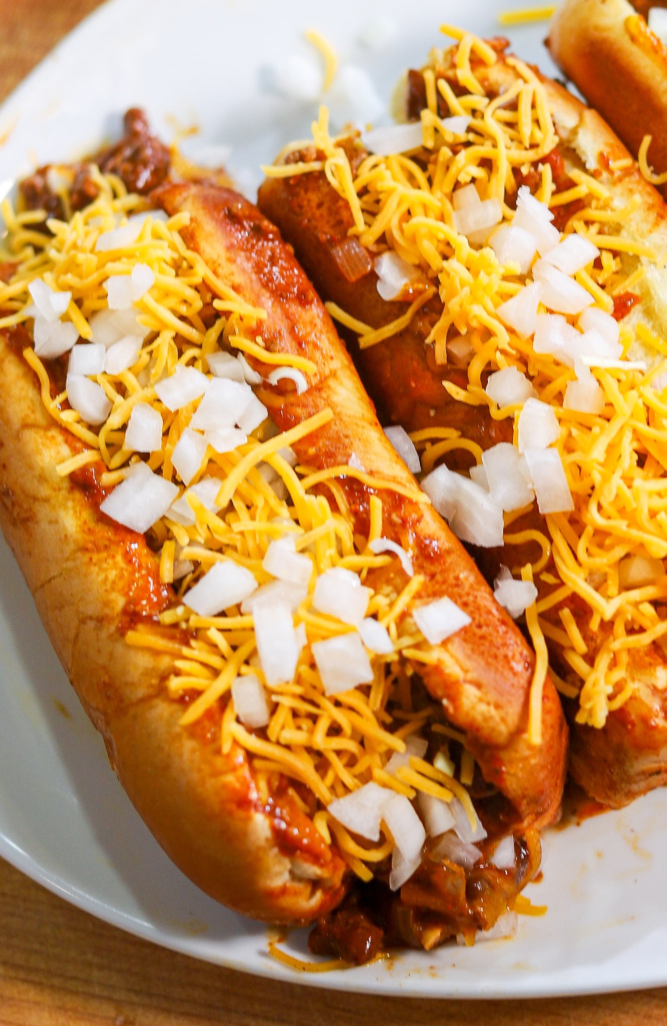 chili dog topped with shredded cheddar cheese